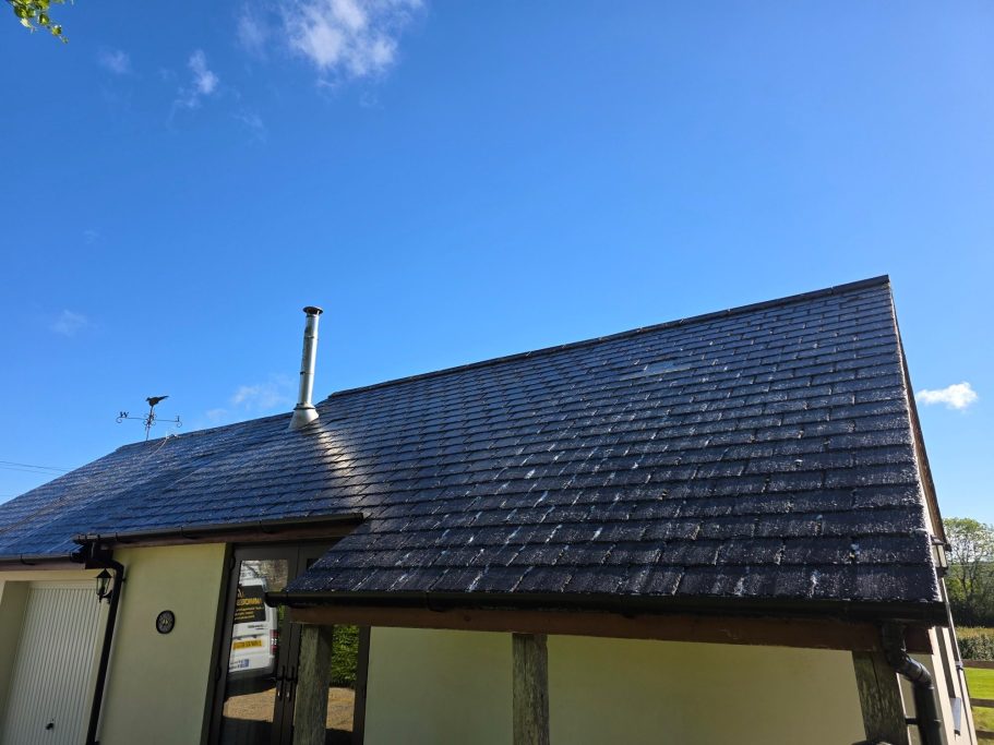 View of a house roof under a clear blue sky.