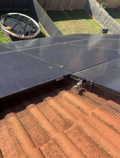 Solar panel Protection In Somerset Solar panels on a rooftop with a tiled surface and a backyard in the background.