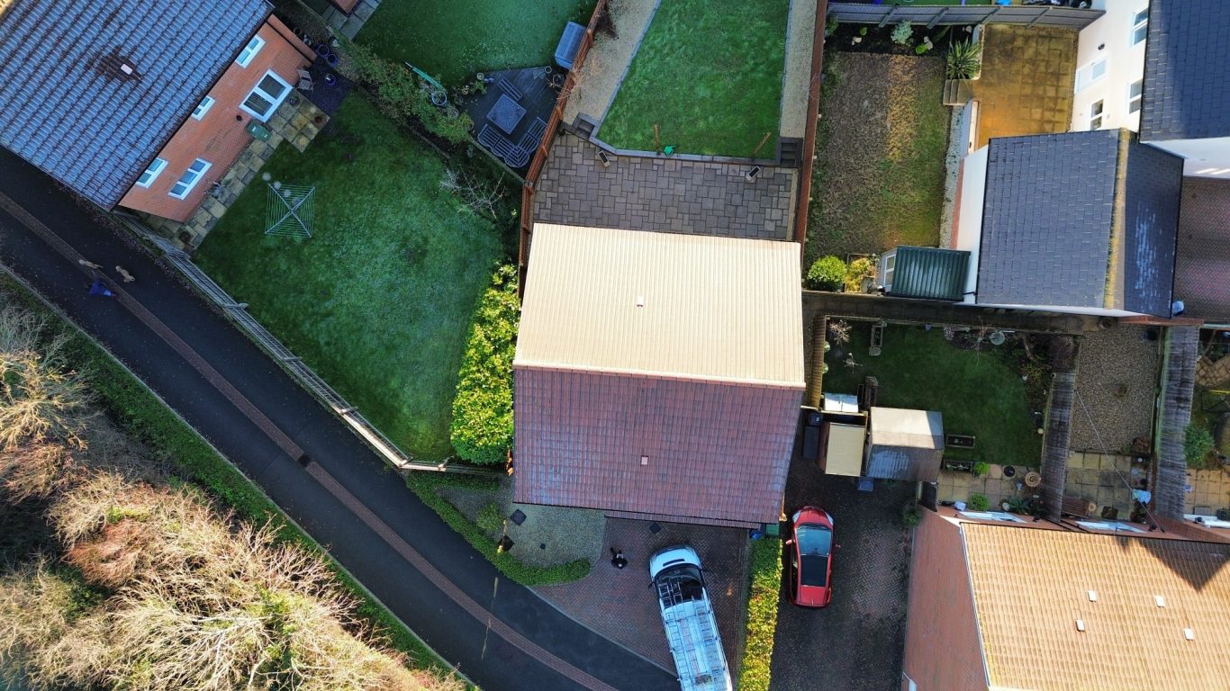 Low pressure wash and biocide treatment in Wellington Aerial view of residential homes and a driveway with parked cars.